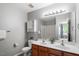 Full bathroom with double sinks, vanity cabinet, updated lighting, and a linen closet at 11210 Lofty Heights Pl, Raleigh, NC 27614