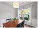 Well-lit dining room with a large window, dark hardwood floors, and classic furnishings at 11210 Lofty Heights Pl, Raleigh, NC 27614
