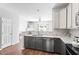 Contemporary kitchen with granite counters, stainless appliances, and a view of the living area at 11210 Lofty Heights Pl, Raleigh, NC 27614