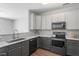 Modern kitchen featuring granite countertops, stainless steel appliances, and sleek gray cabinetry at 11210 Lofty Heights Pl, Raleigh, NC 27614
