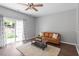 Bright living room featuring a sliding glass door, a leather couch, and a cozy shag rug at 11210 Lofty Heights Pl, Raleigh, NC 27614