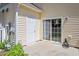 A cozy outdoor patio area with sliding glass doors, a back door, and neat landscaping at 11210 Lofty Heights Pl, Raleigh, NC 27614