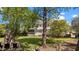 Expansive backyard featuring well-manicured green space, shade trees, and a brick fireplace at 1140 Buttercup Ln, Wake Forest, NC 27587