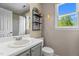Bathroom with a well-lit vanity, decorative shelf, and window, combining style and function at 1140 Buttercup Ln, Wake Forest, NC 27587