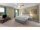 Bedroom features carpeted floors, neutral walls, a ceiling fan, and a large bed with white bedding at 1140 Buttercup Ln, Wake Forest, NC 27587
