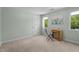 Bedroom with carpet flooring, two windows, and a wooden desk set, providing a cozy and functional space at 1140 Buttercup Ln, Wake Forest, NC 27587