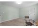 Empty bedroom space with neutral walls, plush carpeting, and a simple chair, offering a versatile area at 1140 Buttercup Ln, Wake Forest, NC 27587