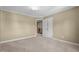 Comfortable bedroom featuring carpet flooring, neutral paint, and a double door leading to a hallway with wood trim at 1140 Buttercup Ln, Wake Forest, NC 27587