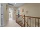 Well-lit hallway with carpeted floors, a wooden banister, and access to multiple rooms at 1140 Buttercup Ln, Wake Forest, NC 27587
