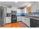 Well-lit kitchen with modern appliances, white cabinetry, a blue backsplash, and light wood flooring at 1140 Buttercup Ln, Wake Forest, NC 27587