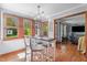 Sunlit eat-in kitchen with wood floors, large windows, white bar stools, and an adjacent seating area at 1140 Buttercup Ln, Wake Forest, NC 27587