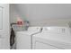 Bright laundry room featuring a white Amana washer and dryer with ample shelving for storage and organization at 1140 Buttercup Ln, Wake Forest, NC 27587