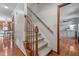 Carpeted stairway with hardwood floors, wooden railing, and white trim at 1140 Buttercup Ln, Wake Forest, NC 27587