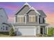 Two-story home with gray shingle and vinyl siding, decorative accents, and a two-car garage at 12 Douglas Fir Pl, Clayton, NC 27520