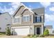 Beautiful two-story house featuring a two-car garage, black door, and well-kept landscaping at 12 Douglas Fir Pl, Clayton, NC 27520
