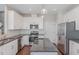 Well-lit kitchen with stainless steel appliances, granite counters and white cabinets at 12 Douglas Fir Pl, Clayton, NC 27520