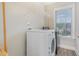 Functional laundry room with washer, dryer, and storage shelves at 12 Douglas Fir Pl, Clayton, NC 27520