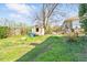 Backyard with grass, shed, mature tree and neighboring house at 1207 Wall St, Durham, NC 27701