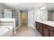 This full bathroom features double sinks, a shower, a tub, and access to the walk-in closet at 126 Elmsford St, Durham, NC 27703