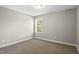This bedroom offers neutral colors, plush carpet, and a window for natural light at 126 Elmsford St, Durham, NC 27703