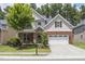 Charming two-story home with a manicured lawn, brick accents, and an attached two-car garage at 126 Elmsford St, Durham, NC 27703