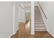 Open hallway with hardwood floors, a carpeted staircase, and a view into the living room at 126 Elmsford St, Durham, NC 27703