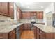 Kitchen with dark wood cabinets, granite countertops, an island, and stainless steel appliances at 126 Elmsford St, Durham, NC 27703