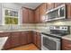 Open kitchen with stainless appliances, granite counters, and dark wood cabinets at 126 Elmsford St, Durham, NC 27703