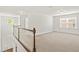 Upstairs loft area with neutral carpet and a view of the stairs and downstairs entryway at 126 Elmsford St, Durham, NC 27703