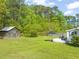 An expansive backyard featuring a storage building, lush green lawn, patio, and privacy fence at 12601 Boyce Mill Rd, Raleigh, NC 27613