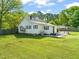 A nice backyard with outdoor seating and a grill, surrounded by a lush green lawn and mature trees at 12601 Boyce Mill Rd, Raleigh, NC 27613