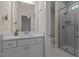 Bathroom featuring a single sink vanity and glass-enclosed shower with marble surround at 1265 Meadow Queen Ln, Apex, NC 27502