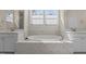 Bathroom featuring a soaking tub with marble surround, and white cabinets at 1265 Meadow Queen Ln, Apex, NC 27502