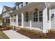 Inviting front porch with white railings and decorative hanging flower baskets at 1265 Meadow Queen Ln, Apex, NC 27502