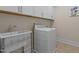 Functional laundry room with utility sink, washing machine and storage cabinets at 1265 Meadow Queen Ln, Apex, NC 27502