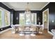 Modern dining room with dark walls, hardwood floors, white trim, and unique light fixture over a spacious table at 1336 Courtland Dr, Raleigh, NC 27604