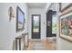 Elegant entryway featuring hardwood floors, sophisticated wall decor, a console table, and a stylish black-framed door at 1336 Courtland Dr, Raleigh, NC 27604