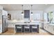 Modern kitchen featuring white cabinets, a large island with seating, stainless steel appliances, and hardwood floors at 1336 Courtland Dr, Raleigh, NC 27604