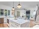 Open kitchen and living room with an island, modern lights, and stainless steel appliances at 1336 Courtland Dr, Raleigh, NC 27604