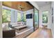 Bright sunroom featuring a ceiling fan, a TV, and comfortable wicker furniture at 1336 Courtland Dr, Raleigh, NC 27604