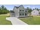 Side view of gray home with two-car garage, long driveway and manicured lawn, under a bright sky at 134 Ivy Ridge Rd, Chapel Hill, NC 27516