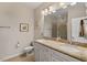 Bathroom featuring a double vanity, granite countertops, a toilet, and glass enclosed shower at 15 Plumas Drive Dr, Durham, NC 27705
