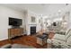 Open living room featuring a fireplace, hardwood floors, and modern decor flowing into the kitchen at 15 Plumas Drive Dr, Durham, NC 27705