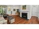 Cozy living room featuring hardwood floors, fireplace, comfortable seating, and natural light from the window at 15 Plumas Drive Dr, Durham, NC 27705