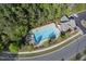 Aerial view of the community pool, surrounded by lush greenery and a nearby clubhouse at 15 Plumas Drive Dr, Durham, NC 27705