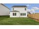 New construction with a lush green lawn, fenced-in yard, and white vinyl siding at 152 Global Ave, Fuquay Varina, NC 27526
