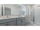 Beautiful bathroom with double sinks, gray cabinets, and glass-enclosed shower at 152 Global Ave, Fuquay Varina, NC 27526