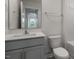 Well-lit bathroom featuring a modern vanity and mirror, with a view through the doorway at 152 Global Ave, Fuquay Varina, NC 27526