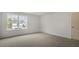 Sunlit bedroom has neutral carpeting and one window overlooking a construction site at 152 Global Ave, Fuquay Varina, NC 27526