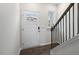 Bright entryway with a white front door, hardwood floors, and a staircase with dark wood railings at 152 Global Ave, Fuquay Varina, NC 27526